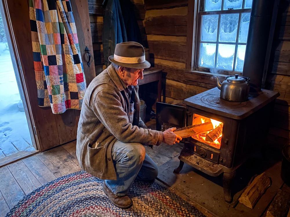 The woodstove in the McCoy cabin, with a quilt hung over the doorway to keep the heat in one room